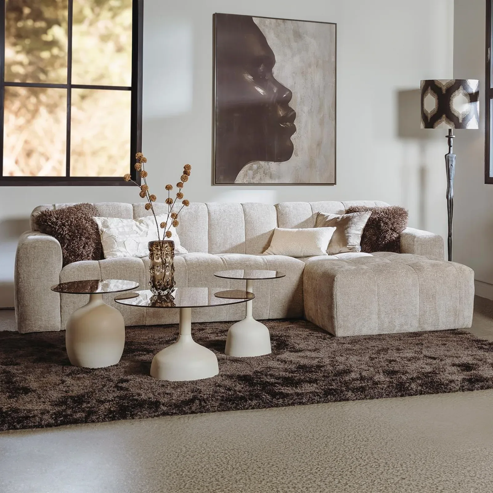 Beige hoekbank in een Japandi zithoek met lage salontafels